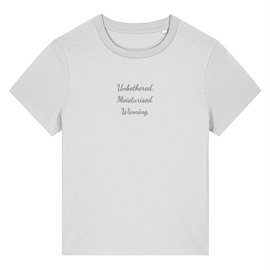 White organic cotton women's t-shirt featuring the confidence quote ‘Unbothered. Moisturised. Winning.’ by Rivaex Clothing